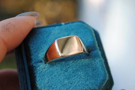Gold ring on a blue cushion with a blurred background