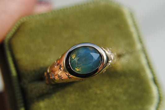 2.15 carat opalescent blue and green sapphire with engraved stars