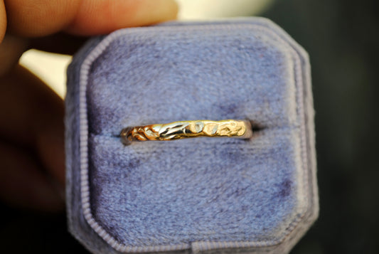 Gold ring on a purple jewelry box with a blurred background