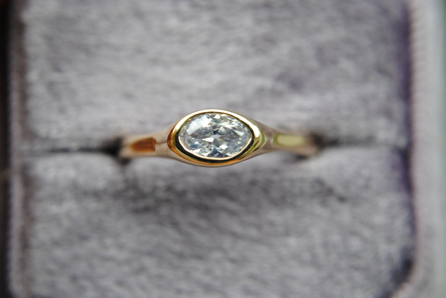 Gold ring with a diamond on a gray background
