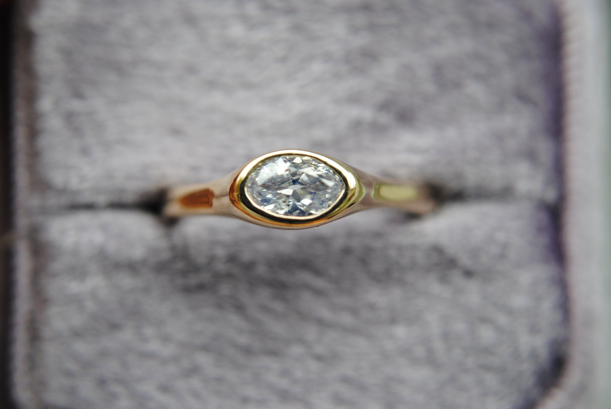 Gold ring with a diamond on a gray background