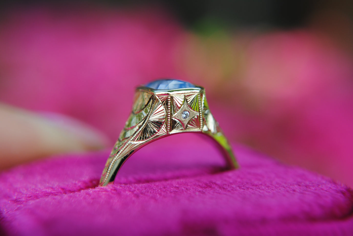 Gold ring with gemstone on a pink fabric background
