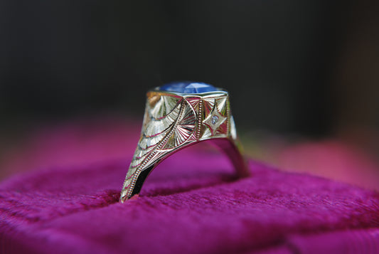 Decorative ring with a blue gemstone on a purple surface