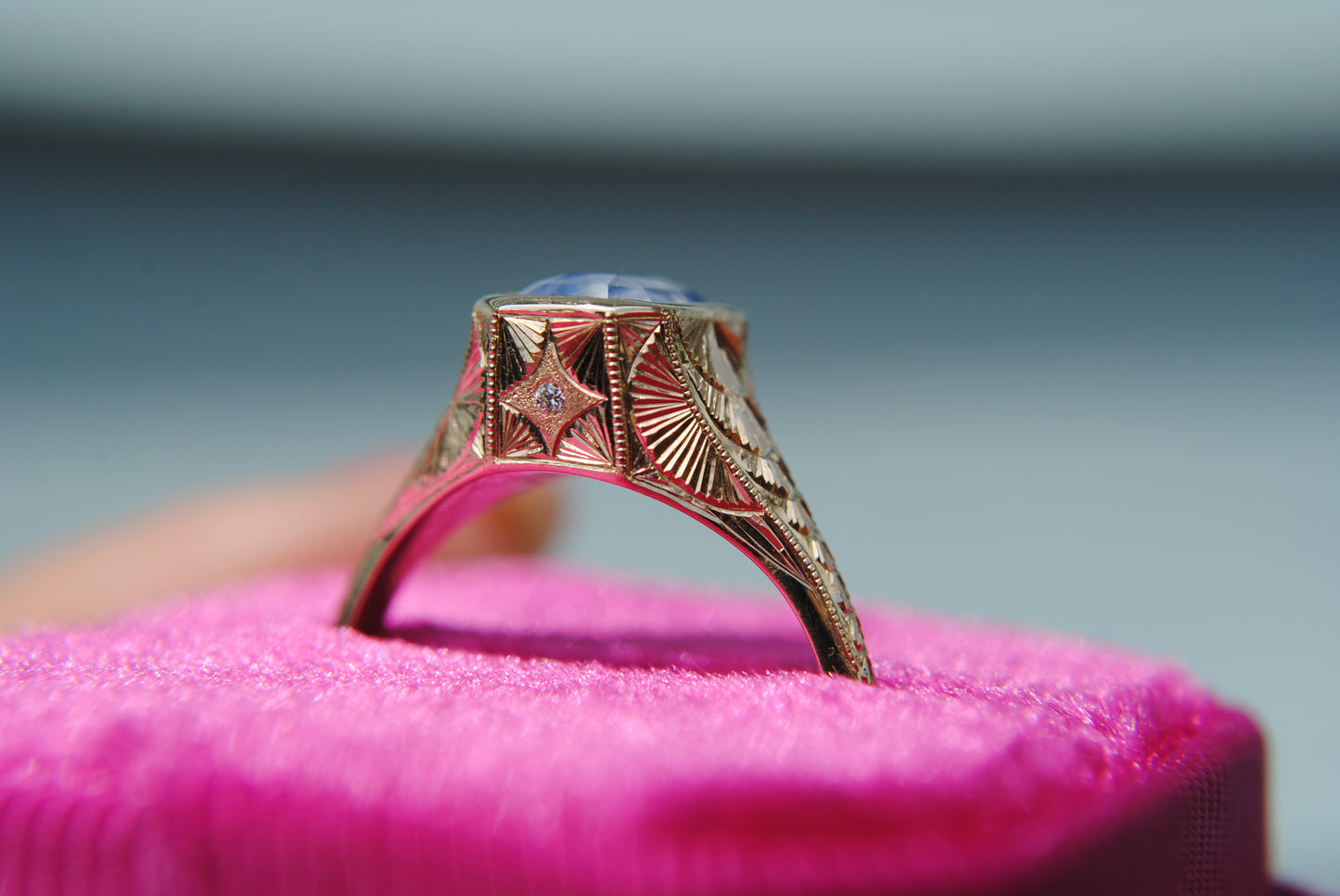 Decorative ring on a pink cushion with a blurred background