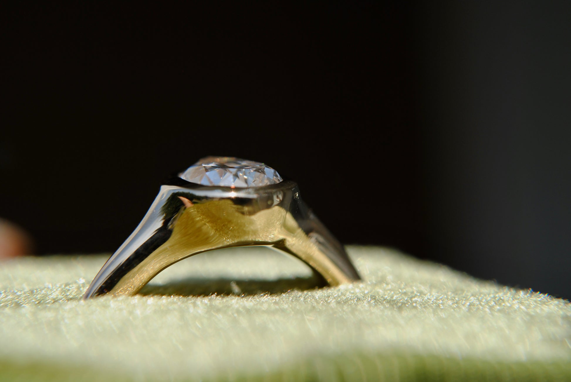 Gold ring with a diamond on a textured surface