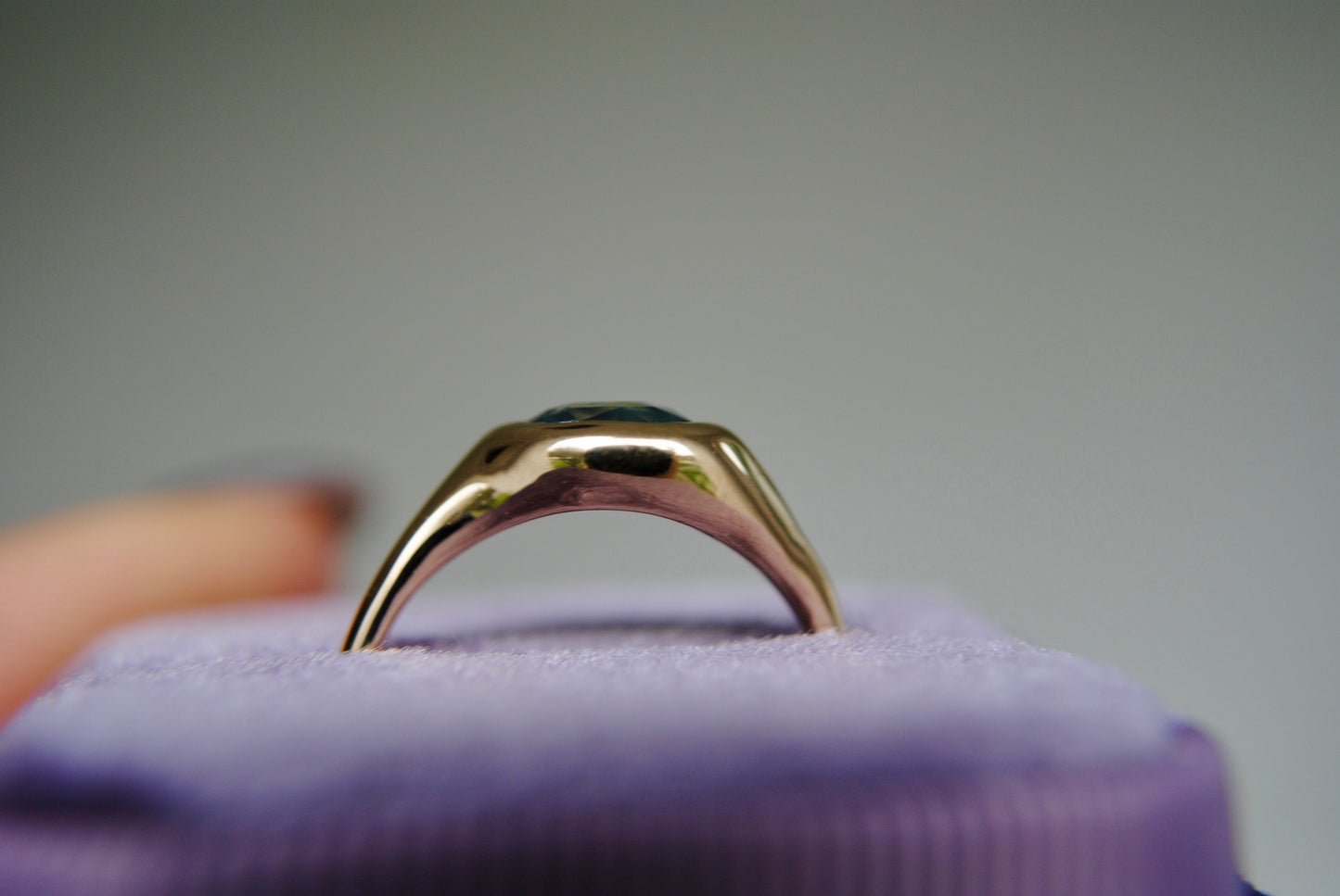 Gold ring on a purple cushion with a blurred background