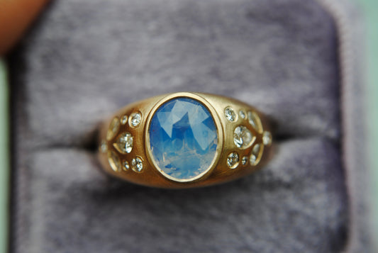sapphire ring with diamonds against a blurry background
