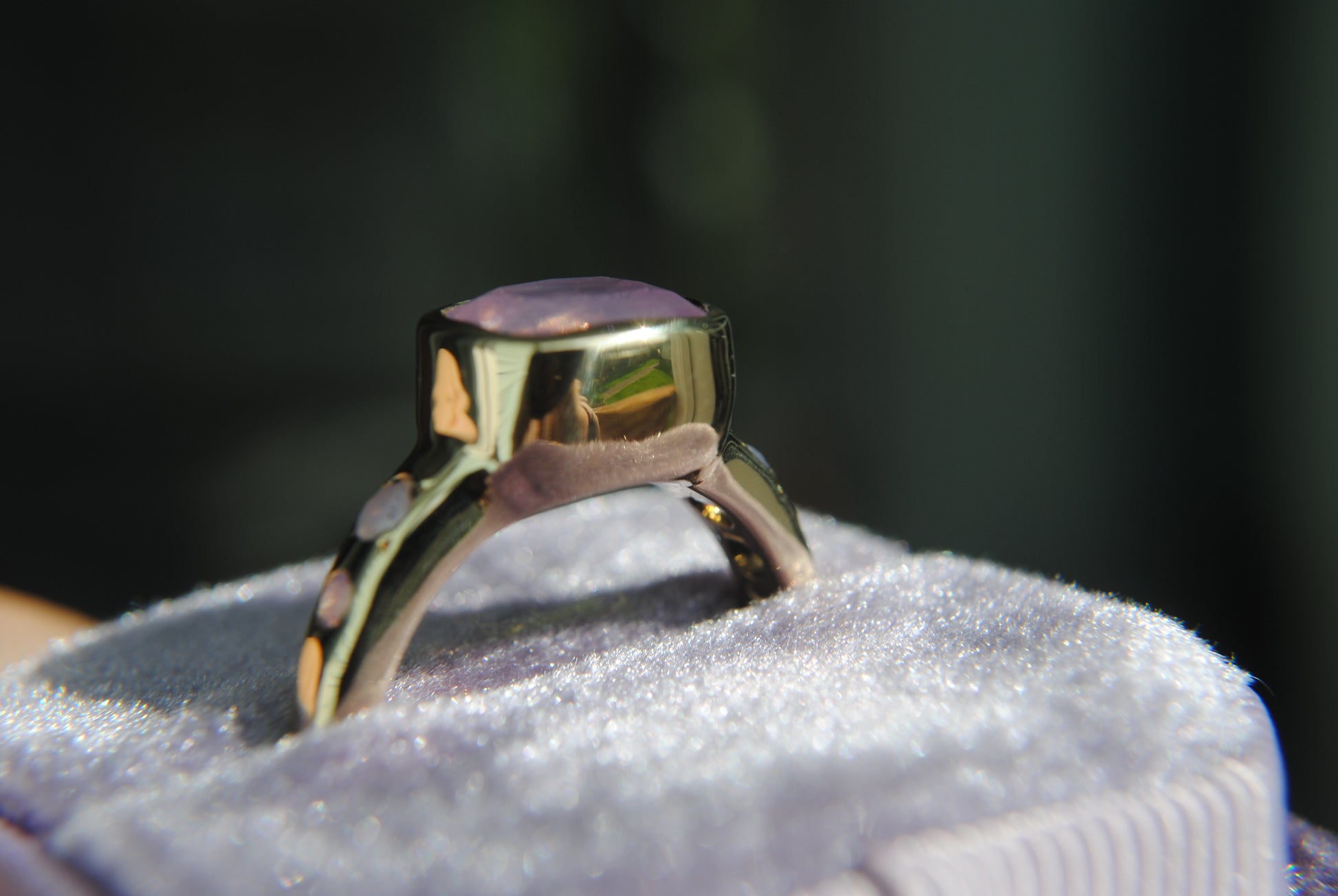 side profile of gold ring with pink stone in a box